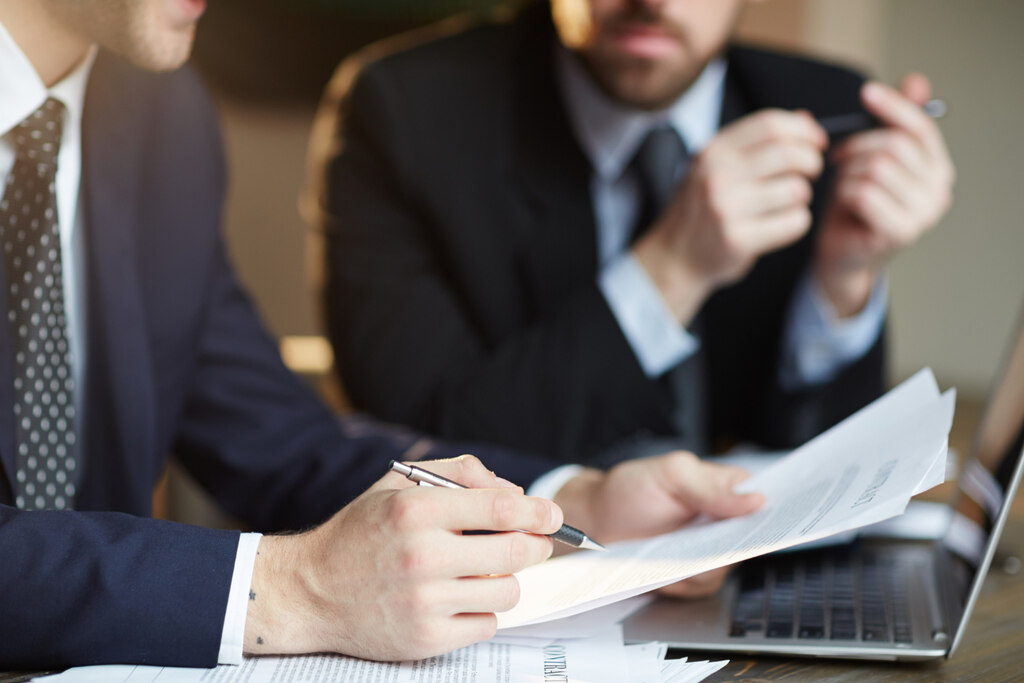 homens realizando assinatura de Garantia de participação em licitação